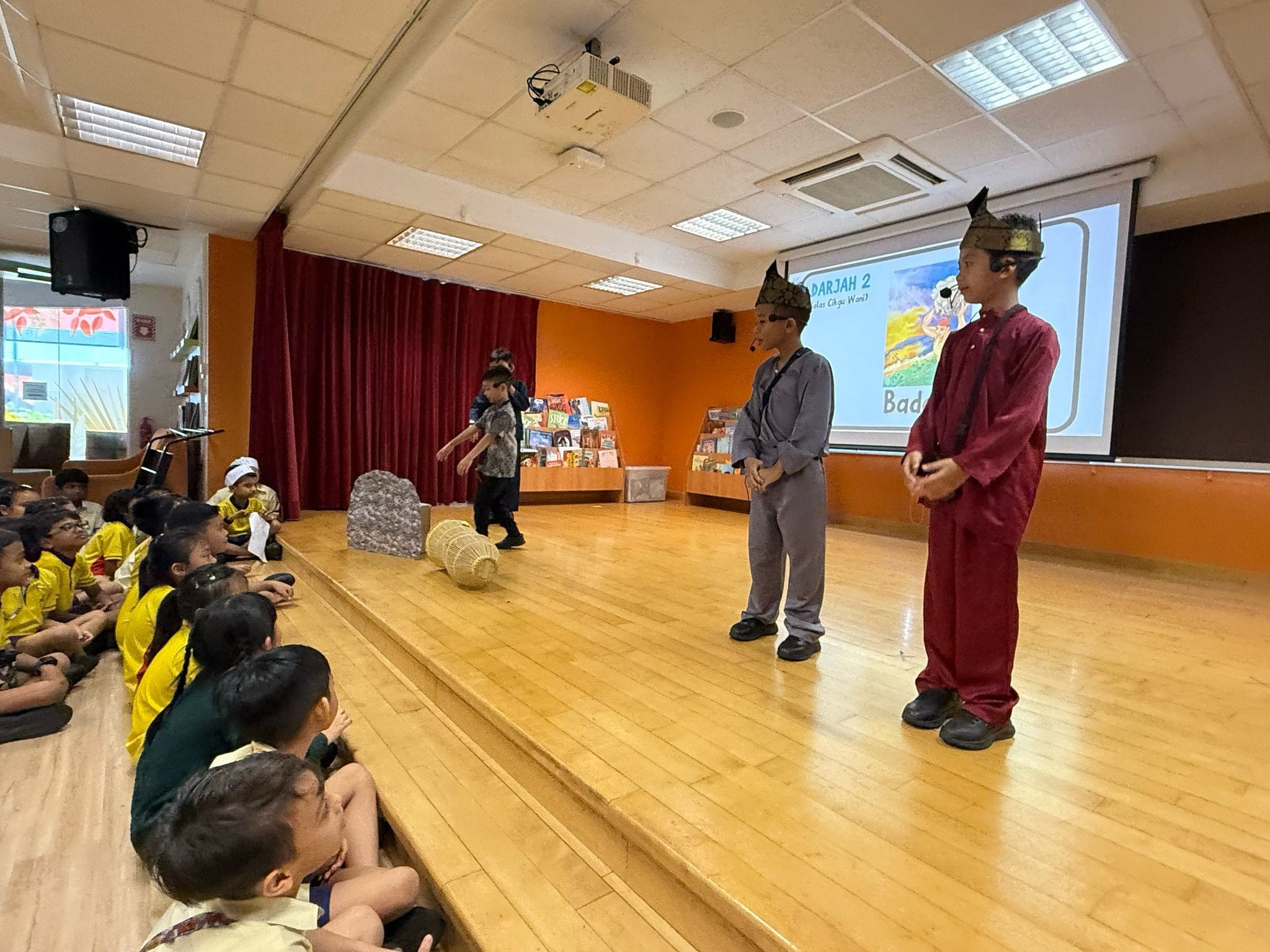 Students on the stage performing "Badang" for their classmates 